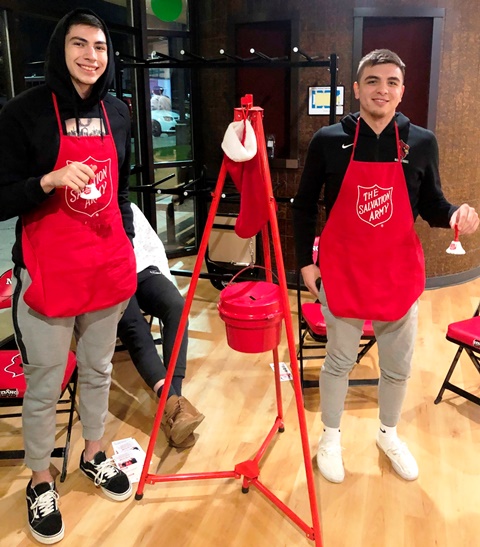 Two male NIC students ringing the bell for the salvation army
